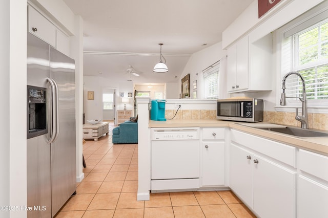 kitchen featuring a sink, a peninsula, stainless steel appliances, and a wealth of natural light