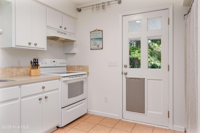 kitchen with light countertops, light tile patterned floors, white cabinets, under cabinet range hood, and white electric range