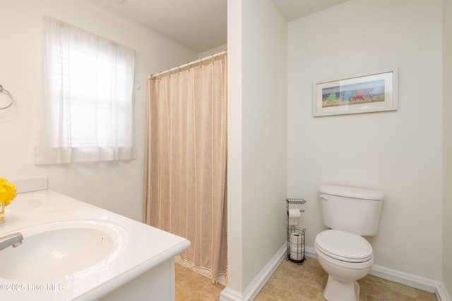 full bath featuring toilet, double vanity, a sink, and curtained shower