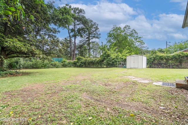 view of yard featuring a fenced backyard, a storage shed, and an outbuilding
