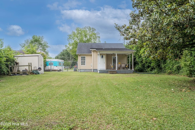 rear view of property featuring a yard and fence