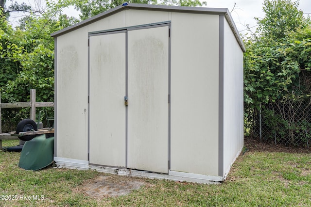 view of shed featuring fence