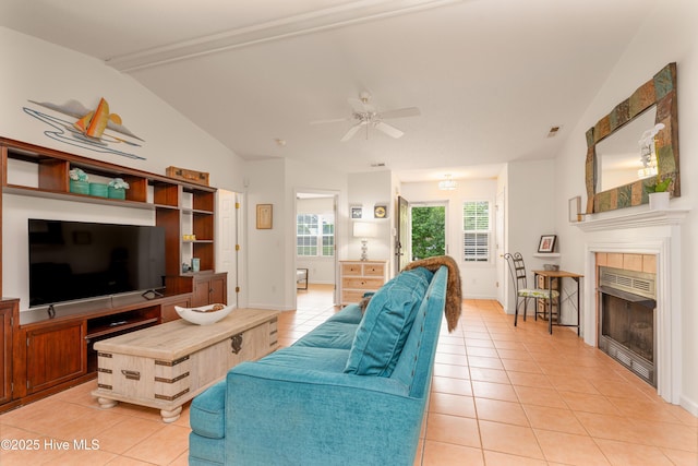 living area with a ceiling fan, light tile patterned floors, visible vents, vaulted ceiling, and a tile fireplace