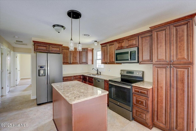 kitchen with appliances with stainless steel finishes, a sink, a center island, pendant lighting, and brown cabinets