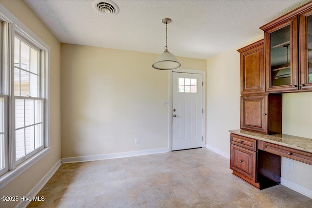 unfurnished office with baseboards, light flooring, and a textured ceiling