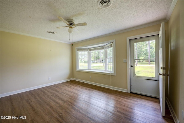 spare room featuring dark wood finished floors, a textured ceiling, a ceiling fan, ornamental molding, and baseboards