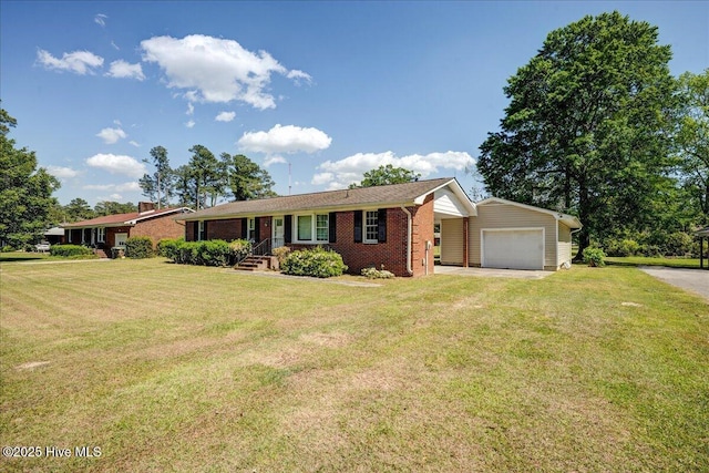 single story home with brick siding, a front yard, driveway, and an outdoor structure