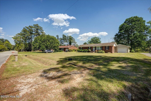 view of green lawn featuring a detached garage
