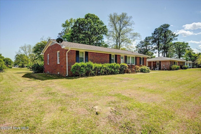 single story home with brick siding and a front yard