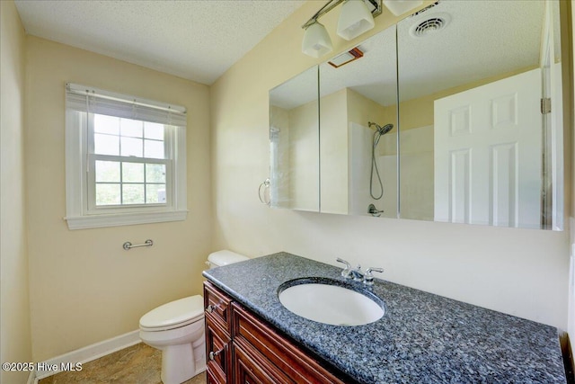 bathroom with toilet, vanity, baseboards, a textured ceiling, and a shower