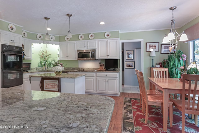 1 Collett Ln, Pinehurst, NC 28374 - kitchen with stainless steel microwave, white cabinetry, ornamental molding, and a textured ceiling