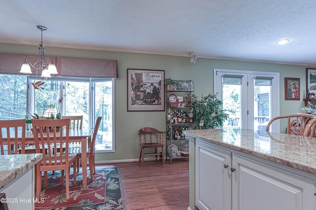 1 Collett Ln, Pinehurst, NC 28374 - dining area with a chandelier, healthy amount of natural light, dark wood-type flooring, a textured ceiling, and baseboards