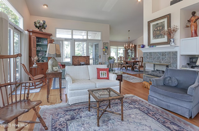 12 Shenecossett Ln, Pinehurst, NC 28374 - living room featuring wood finished floors, healthy amount of natural light, a chandelier, a tiled fireplace, and vaulted ceiling
