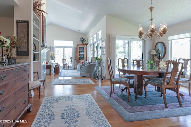 12 Shenecossett Ln, Pinehurst, NC 28374 - dining area with lofted ceiling, a chandelier, wood finished floors, and a textured ceiling