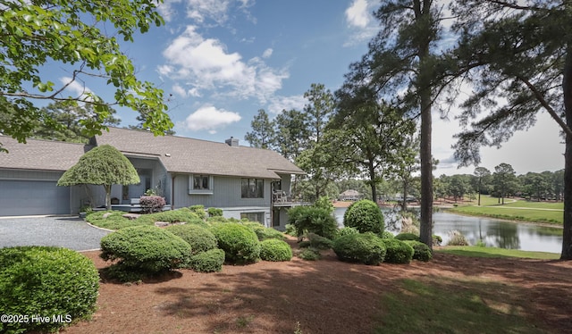 12 Shenecossett Ln, Pinehurst, NC 28374 - view of front of house with a water view, a garage, gravel driveway, a chimney, and roof with shingles
