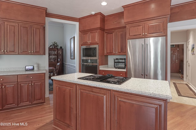 127 Sakonnet Trl, Pinehurst, NC 28374 - kitchen featuring appliances with stainless steel finishes, light wood-type flooring, a kitchen island, brown cabinets, and recessed lighting
