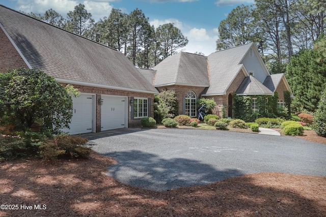 127 Sakonnet Trl, Pinehurst, NC 28374 - view of front of property featuring asphalt driveway, brick siding, an attached garage, and a shingled roof