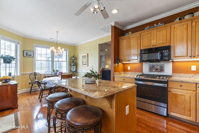 3243 Marsh View Dr SW, Supply, NC 28462 - kitchen featuring black microwave, stainless steel range with gas stovetop, a breakfast bar area, dark wood-style flooring, and light stone counters