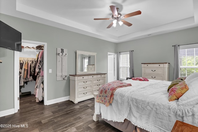 133 Fallbrook Ln, Rocky Point, NC 28457 - bedroom featuring a tray ceiling, dark wood finished floors, a spacious closet, baseboards, and a closet