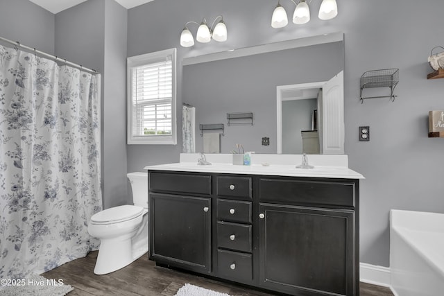 133 Fallbrook Ln, Rocky Point, NC 28457 - full bathroom featuring wood finished floors, toilet, double vanity, a shower with curtain, and a tub to relax in
