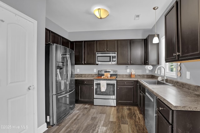 133 Fallbrook Ln, Rocky Point, NC 28457 - kitchen featuring stainless steel appliances, a sink, dark wood-style flooring, dark brown cabinetry, and pendant lighting