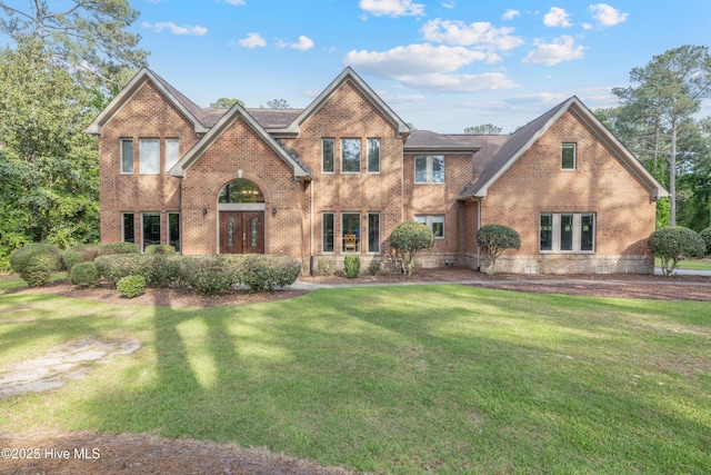 view of front facade with a front yard and brick siding