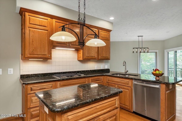 kitchen with dishwasher, gas cooktop, a textured ceiling, a sink, and brown cabinets