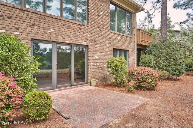 view of side of home with a patio area and brick siding