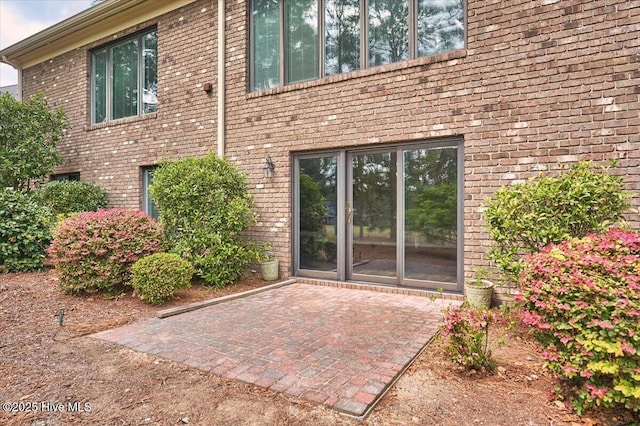 entrance to property with a patio and brick siding