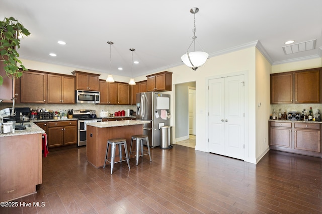1427 Hammocks Beach Rd, Swansboro, NC 28584 - kitchen featuring appliances with stainless steel finishes, crown molding, tasteful backsplash, a center island, and light stone countertops