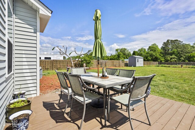 1427 Hammocks Beach Rd, Swansboro, NC 28584 - wooden deck featuring a storage shed, outdoor dining space, and an outbuilding