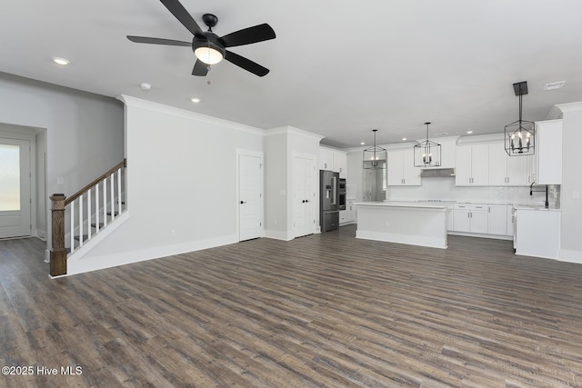 738 Hollybriar Loop Rd SE, Bolivia, NC 28422 - unfurnished living room with recessed lighting, ceiling fan, dark wood-style floors, stairway, and ornamental molding