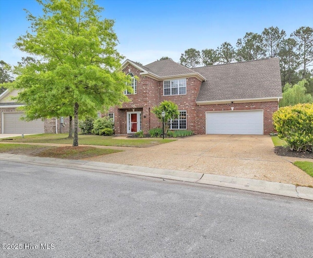 view of front facade with brick siding, an attached garage, concrete driveway, a front yard, and roof with shingles