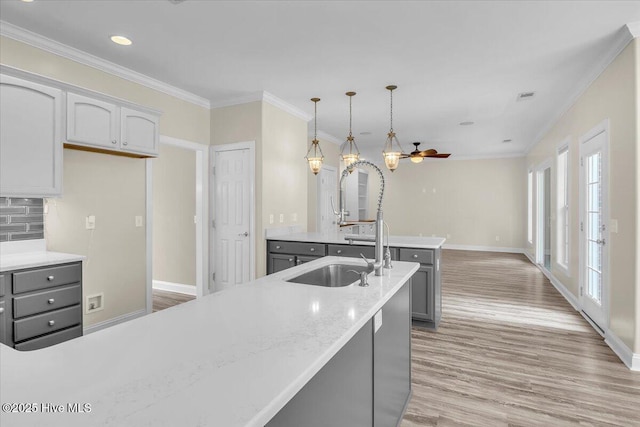kitchen featuring ornamental molding, baseboards, gray cabinets, and light wood-style floors