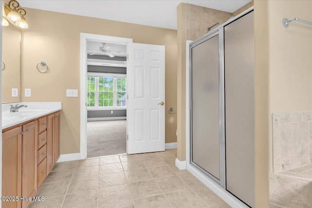 full bath with vanity, baseboards, and a shower stall