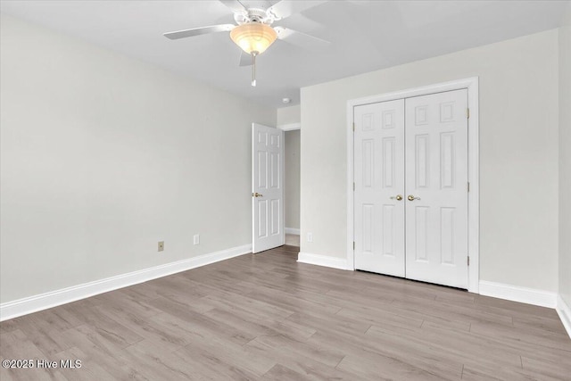 unfurnished bedroom with ceiling fan, baseboards, a closet, and wood finished floors