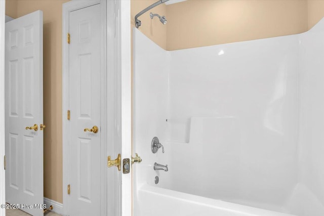 full bathroom with tub / shower combination and baseboards
