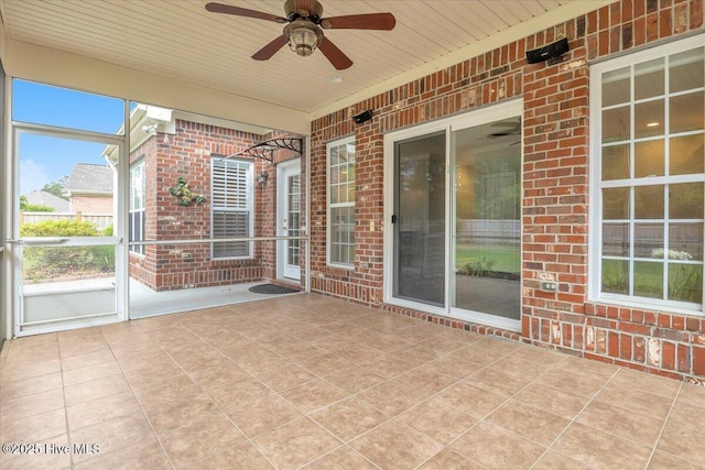 unfurnished sunroom with ceiling fan