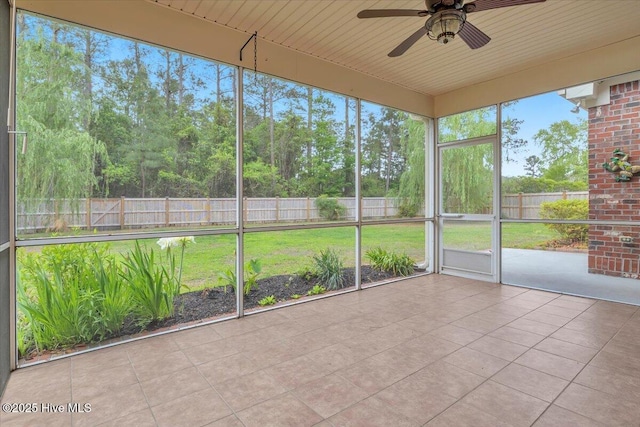 unfurnished sunroom featuring a ceiling fan and a wealth of natural light