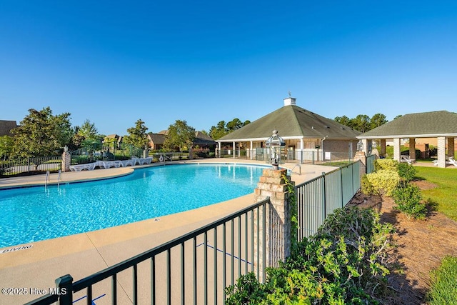 pool featuring a gazebo, fence, and a patio area