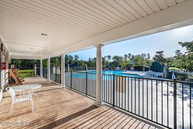 community pool with a patio and fence