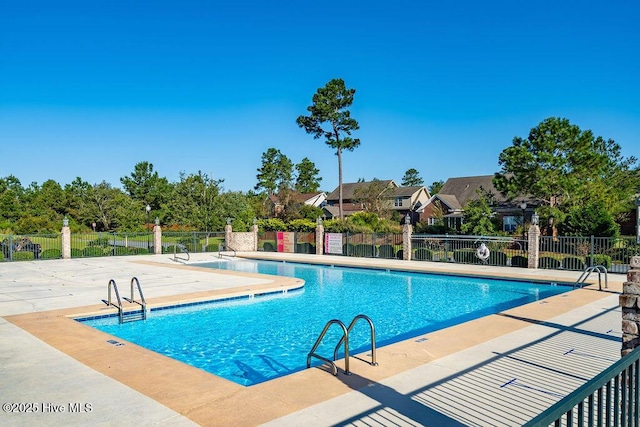 pool with a patio and fence