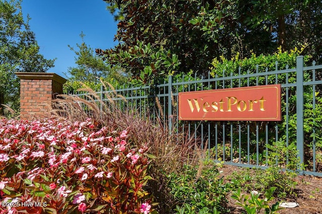 community / neighborhood sign featuring fence