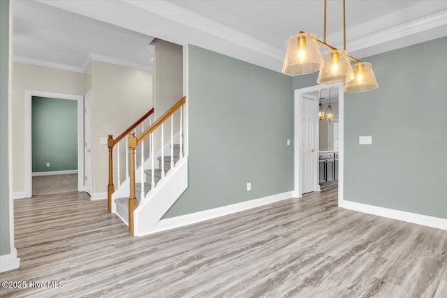 unfurnished room with crown molding, stairs, wood finished floors, and a notable chandelier