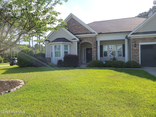view of front of property with stone siding, a front yard, and a garage