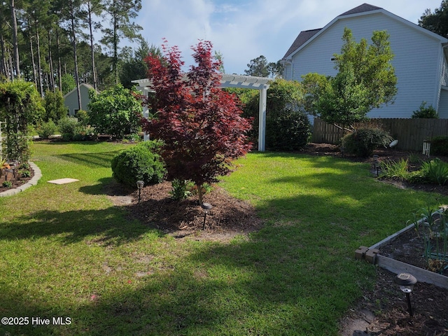 view of yard featuring a vegetable garden, a pergola, and fence