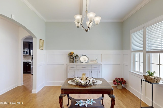 429 Canvasback Ln, Sneads Ferry, NC 28460 - dining space with light wood-type flooring, arched walkways, a decorative wall, ornamental molding, and a chandelier