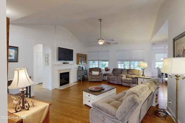 429 Canvasback Ln, Sneads Ferry, NC 28460 - living room featuring arched walkways, ceiling fan, wood finished floors, high vaulted ceiling, and a fireplace with flush hearth
