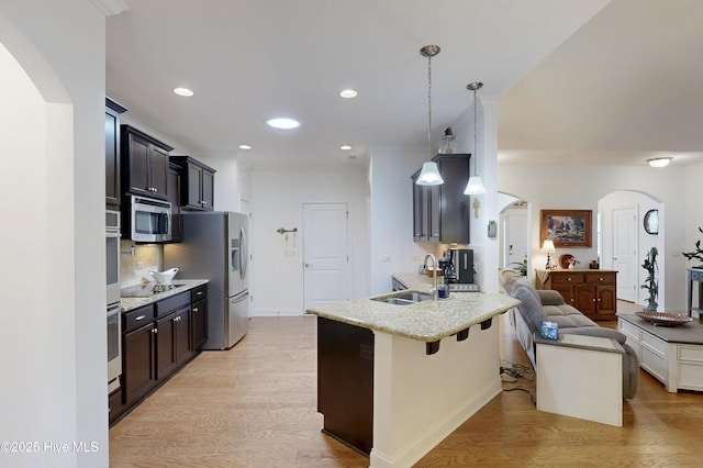 429 Canvasback Ln, Sneads Ferry, NC 28460 - kitchen with arched walkways, a sink, stainless steel appliances, a breakfast bar, and recessed lighting