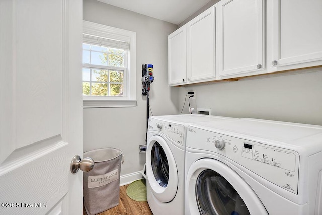laundry area featuring baseboards, washer and dryer, cabinet space, and wood finished floors